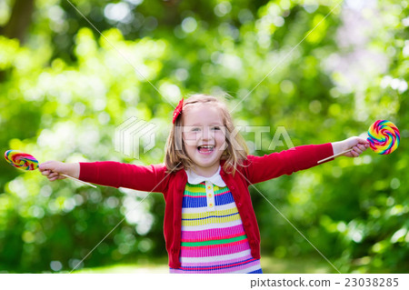 Little girl with colorful candy lollipop 23038285