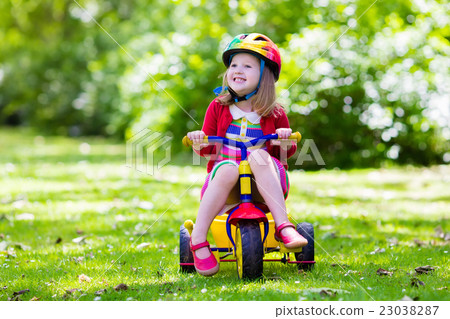 Little girl riding a tricycle 23038287