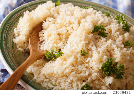Boiled crumbly bulgur with herbs macro on a plate Boiled crumbly bulgur with herbs macro on a plate 23039421