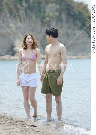 A couple nestling at the beach 23042345