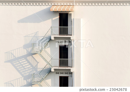 fire escape with afternoon shadows on wall. fire escape with afternoon shadows on wall. 23042678