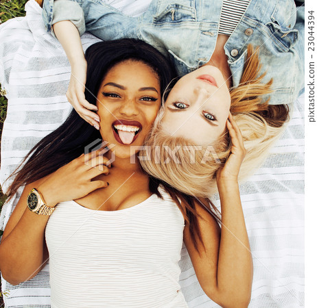 two pretty girls on grass happy smiling, best 23044394