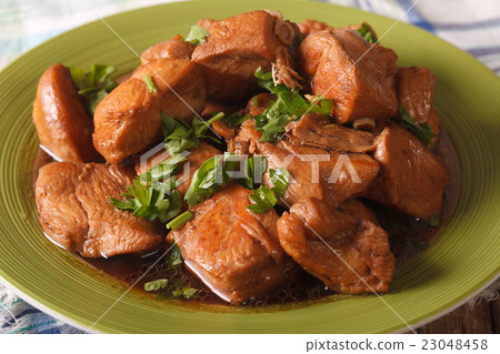 Adobo Chicken with herbs close-up on a plate 23048458