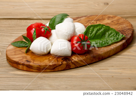 Mozzarella, heirloom tomatoes, basil leaves Mozzarella, heirloom tomatoes, basil leaves 23048942