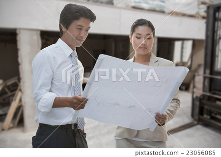 Composite image of estate agent and buyer looking at blueprint Composite image of estate agent and buyer looking at blueprint 23056085