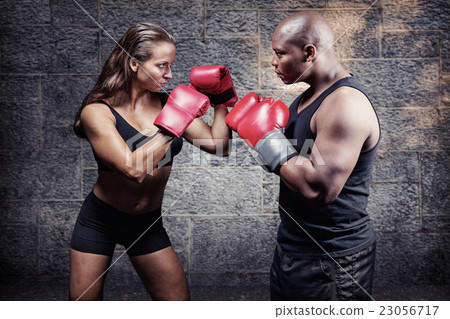 Composite image of male and female boxer with fighting stance 23056717