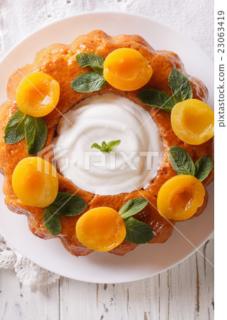 Tasty cake Savarin with apricots and mint close-up 23063419