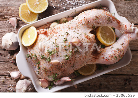 raw whole chicken marinated with garlic, thyme raw whole chicken marinated with garlic, thyme 23063559