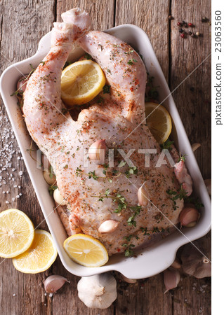 raw whole chicken marinated with garlic, thyme raw whole chicken marinated with garlic, thyme 23063560