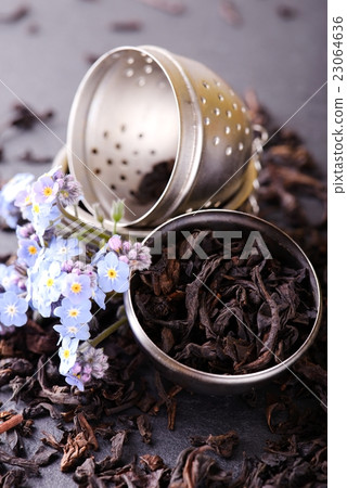 Strainer full of dry tea leaves with blue flower 23064636