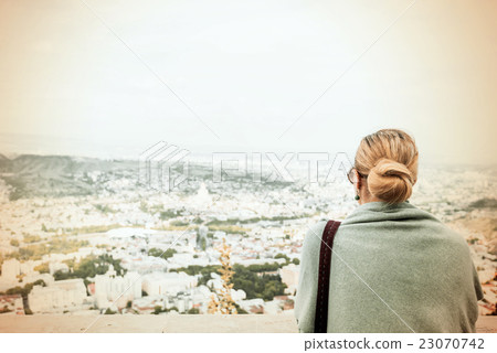 Back view of a woman with tied blond hair.. Back view of a woman with tied blond hair.. 23070742
