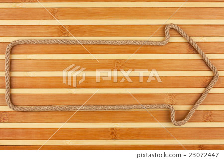 Arrow made of rope lies on a bamboo mat Arrow made of rope lies on a bamboo mat 23072447