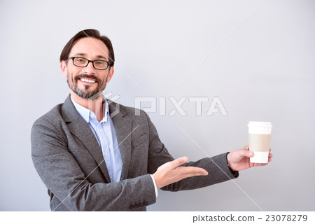 Man pointing at cup of coffee Man pointing at cup of coffee 23078279