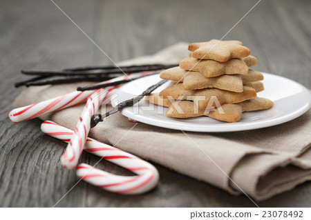 holiday cookies and candy canes on wood table 23078492