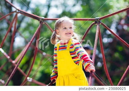 Child having fun on school yard playground Child having fun on school yard playground 23080025