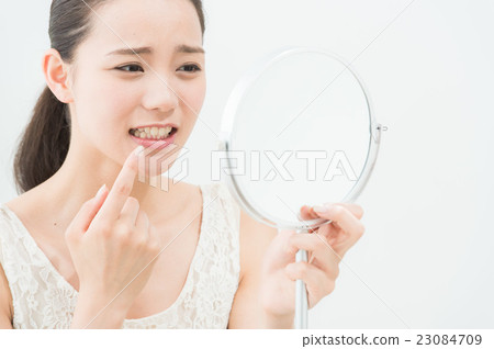 A woman looking at a mirror (dental care) A woman looking at a mirror (dental care) 23084709