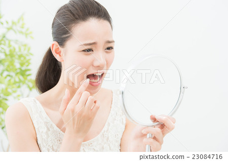 A woman looking at a mirror (dental care) A woman looking at a mirror (dental care) 23084716