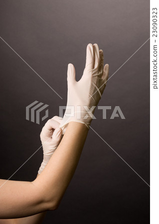 Putting on latex gloves Putting on latex gloves 23090323