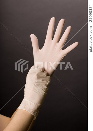 Putting on latex gloves Putting on latex gloves 23090324