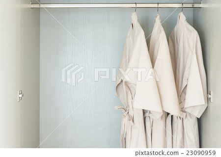 bathrobe hanging on rail in wooden wardrobe 23090959
