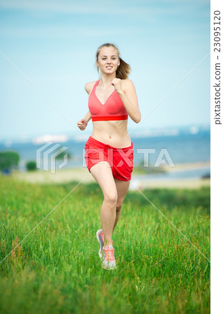 Young woman running summer park rural road 23095120