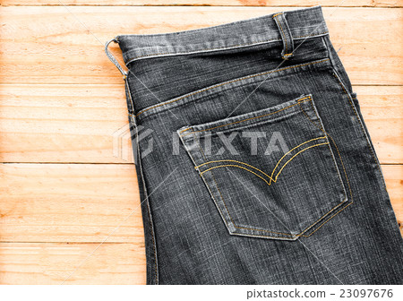 the black jeans on wooden background the black jeans on wooden background 23097676