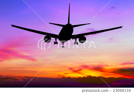 Silhouetted commercial airplane flying at sunset Silhouetted commercial airplane flying at sunset 23098138