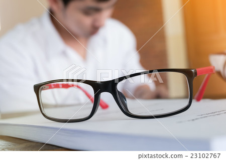 eye glasses placed on a blank paper sheet 23102767