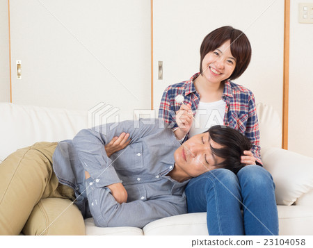 Couples doing ear cleaning with knee pillow 23104058