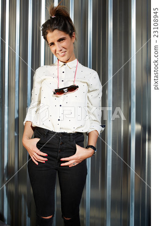 Woman is standing near shiny chrome wall Woman is standing near shiny chrome wall 23108945