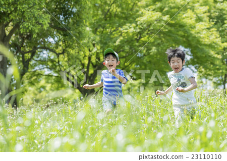 Elementary school students running in a fresh green park 23110110