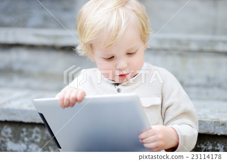 Cute toddler boy playing with a digital tablet 23114178