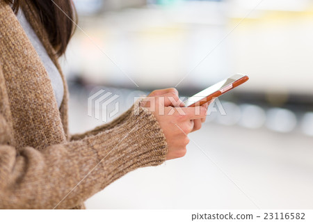 Woman use of mobile phone in train station 23116582