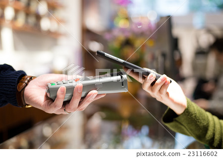Woman pay with cellphone by NFC Woman pay with cellphone by NFC 23116602