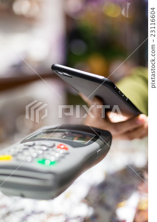 Woman paying with NFC technology on celphone 23116604