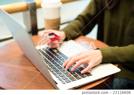 Woman use of notebook computer with credit card for online shopping Woman use of notebook computer with credit card for online shopping 23116606