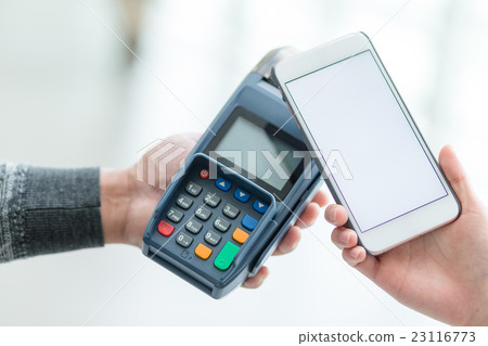 Woman using cellphone for paying the bill Woman using cellphone for paying the bill 23116773