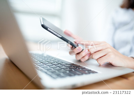 Female hands using smart phone and working with computer 23117322