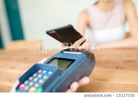 Woman paying with NFC technology on mobile phone 23117330