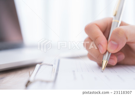 Hand with pen over application form.. 23118307