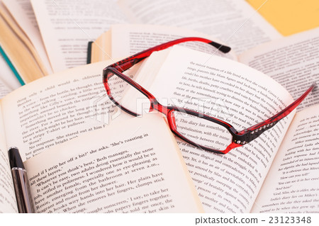 Opened books, eyeglasses and pen Opened books, eyeglasses and pen 23123348