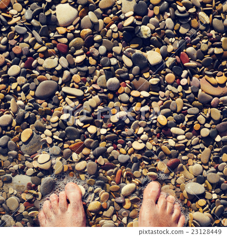 young man in the seashore of a shingle beach young man in the seashore of a shingle beach 23128449