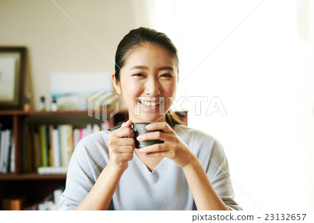A woman eating yoghurt after breakfast 23132657