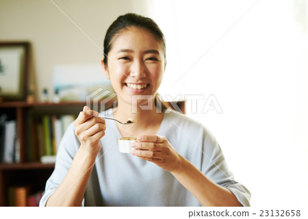 吃酸奶的婦女在早餐以後 23132658