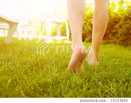 Close up female legs walking on the grass. 23153043