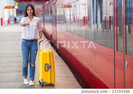 Young caucasian girl with luggage at station 23154380
