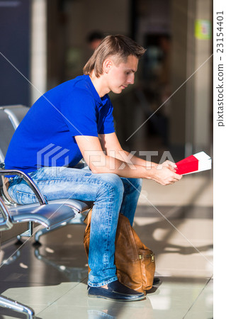 Young manwith passports and boarding pass at Young manwith passports and boarding pass at 23154401