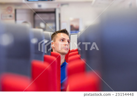 Young happy man traveling by train Young happy man traveling by train 23154448