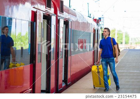 Young caucasian man with luggage at station Young caucasian man with luggage at station 23154475