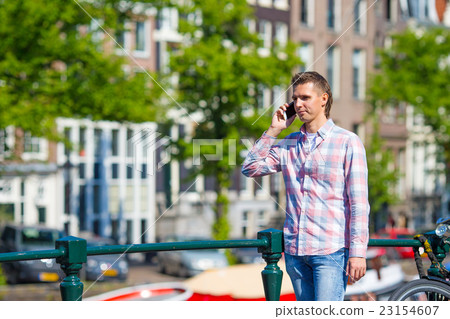 Young caucasian man talking by cell phone on Young caucasian man talking by cell phone on 23154607